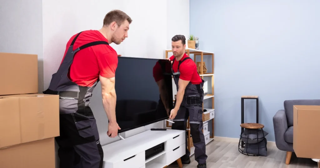 How to Choose a Professional Furniture Moving Service in Birmingham 5 Furniture moving professionals carefully wrapping and loading a sofa in Birmingham.